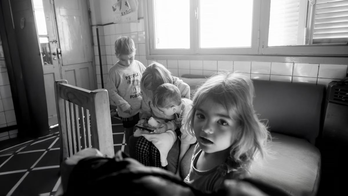 A candid black and white photo of children interacting indoors, creates a classic moment.